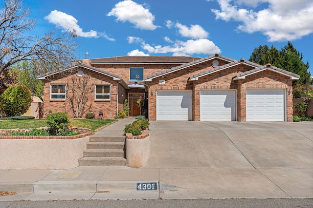 view of front of home with concrete driveway, brick siding, and an attached garage