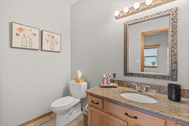 bathroom featuring tile patterned floors, toilet, vanity, and baseboards