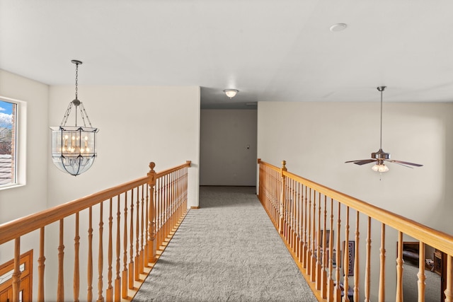 hall featuring carpet floors and a chandelier