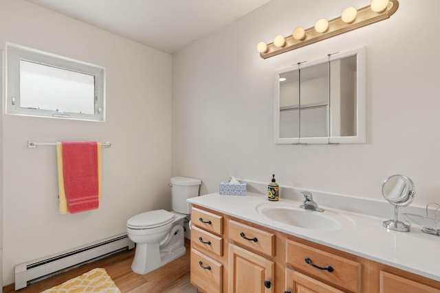 bathroom with toilet, a baseboard radiator, vanity, and wood finished floors