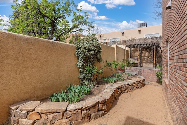 view of yard featuring fence and a pergola