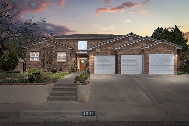 view of front facade featuring brick siding, driveway, and an attached garage
