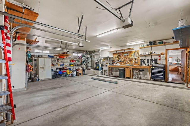 garage with a workshop area and a garage door opener