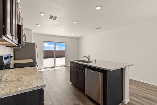 2522 Desi Loop, Belen, NM 87002 - kitchen featuring appliances with stainless steel finishes, a sink, dark wood-style floors, a kitchen island with sink, and recessed lighting