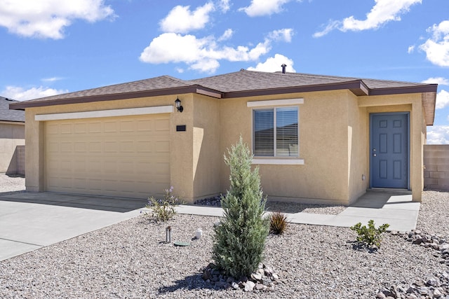 2522 Desi Loop, Belen, NM 87002 - view of front facade with a garage, stucco siding, and concrete driveway