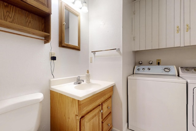 bathroom with washing machine and dryer, toilet, and vanity