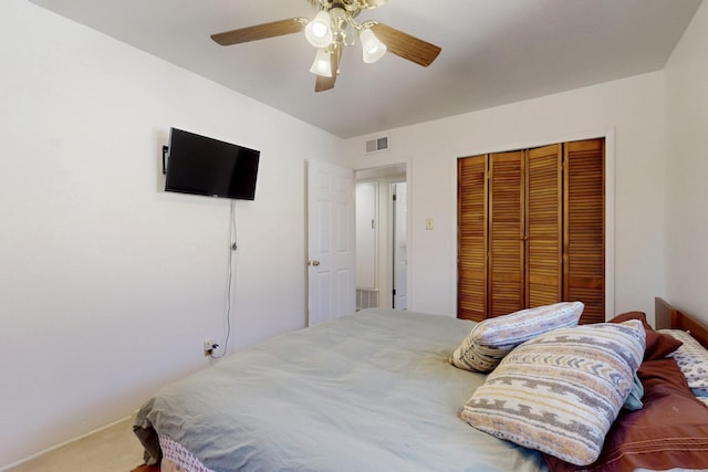 carpeted bedroom with a ceiling fan, a closet, and visible vents