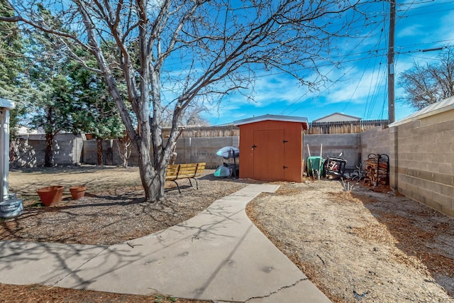 view of yard with a fenced backyard, an outbuilding, and a storage shed