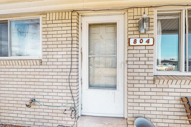 property entrance featuring brick siding