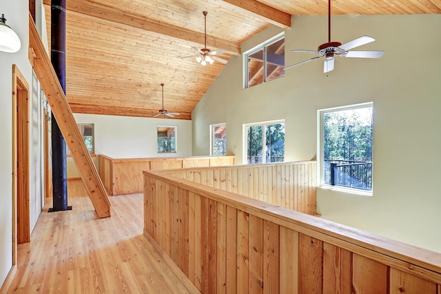hallway with an upstairs landing, wooden ceiling, high vaulted ceiling, beam ceiling, and light wood-style floors