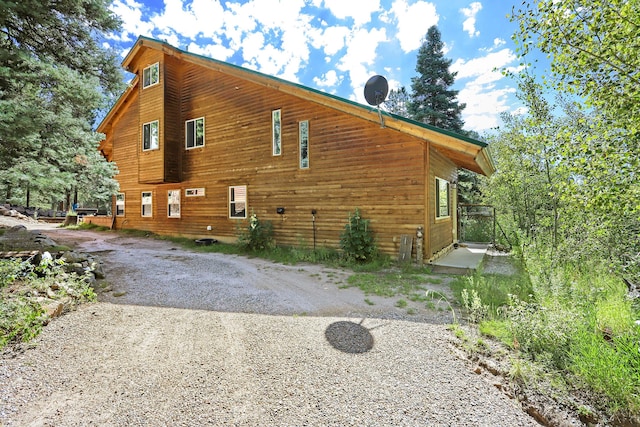 view of side of property featuring gravel driveway