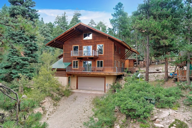 view of front of home featuring driveway, a garage, and a balcony