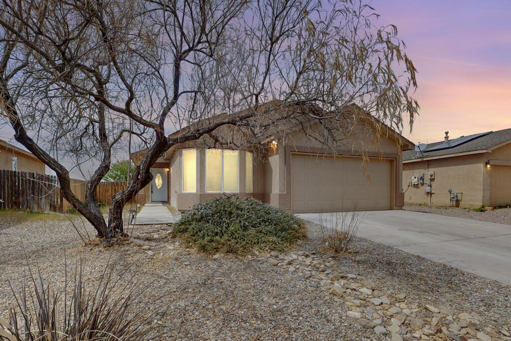 34 Tome Vista Dr, Los Lunas, NM 87031 - view of front facade featuring stucco siding, driveway, a garage, and fence