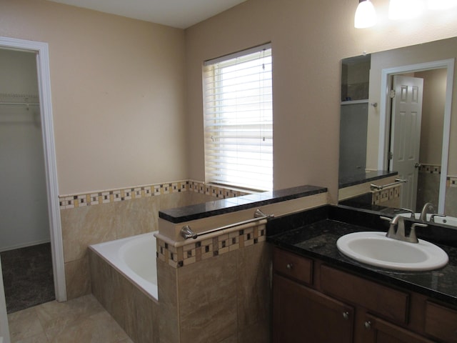 bathroom with a garden tub and vanity