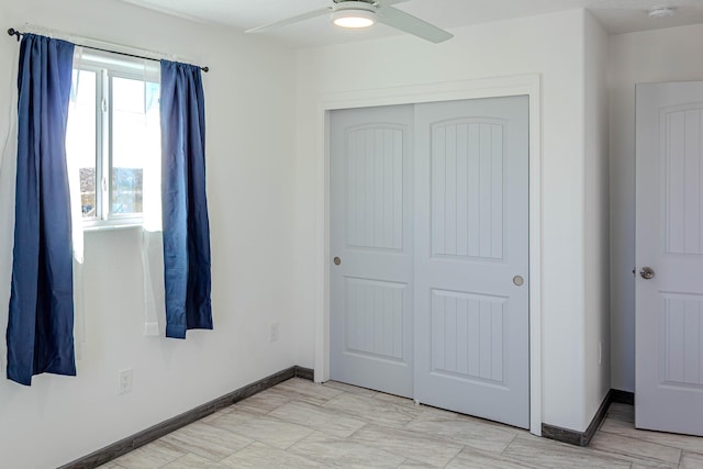 unfurnished bedroom featuring a closet, ceiling fan, and baseboards
