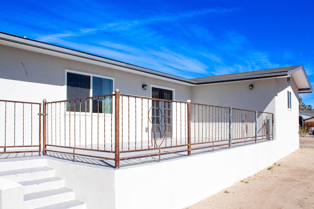 back of property featuring stucco siding and fence