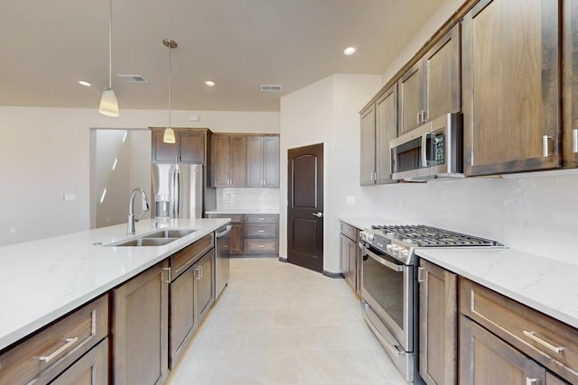 kitchen featuring a sink, tasteful backsplash, visible vents, hanging light fixtures, and appliances with stainless steel finishes