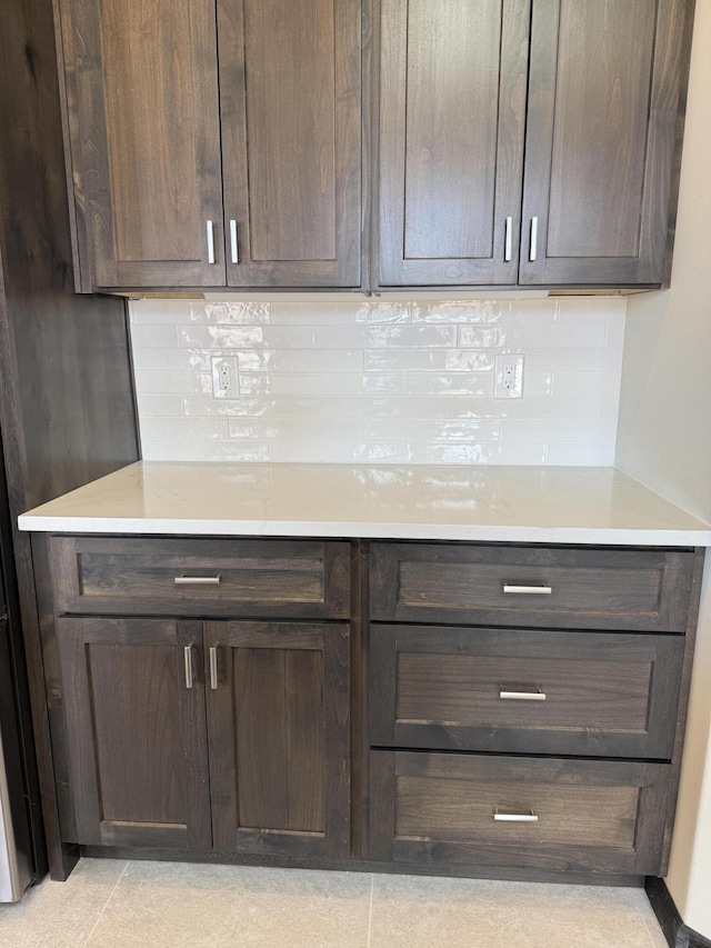 interior space with dark brown cabinets, backsplash, and light countertops