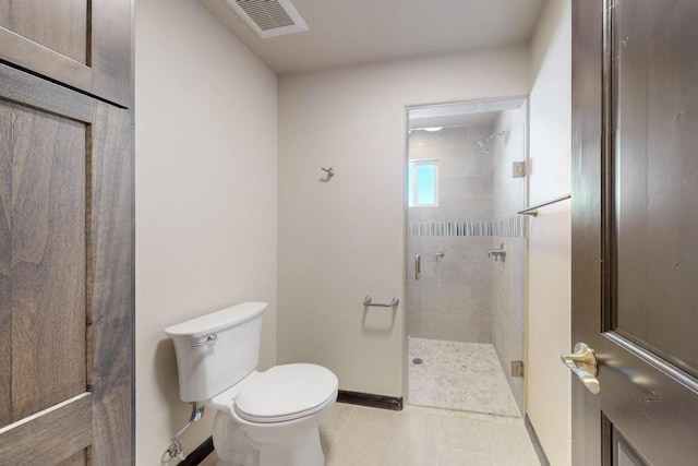 bathroom with toilet, a stall shower, visible vents, baseboards, and tile patterned flooring