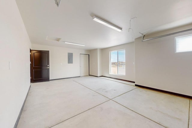 garage featuring electric panel and baseboards