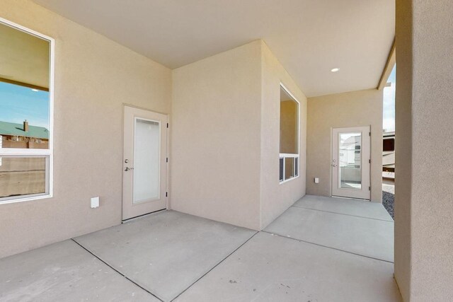 entrance to property with stucco siding and a patio area