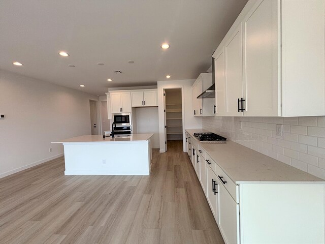3225 Matador St SE, Rio Rancho, NM 87144 - kitchen featuring appliances with stainless steel finishes, recessed lighting, light wood-type flooring, tasteful backsplash, and white cabinets