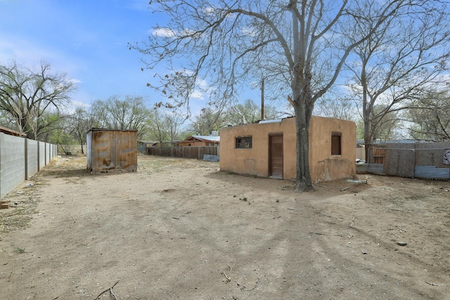view of yard with an outdoor structure, a shed, and fence