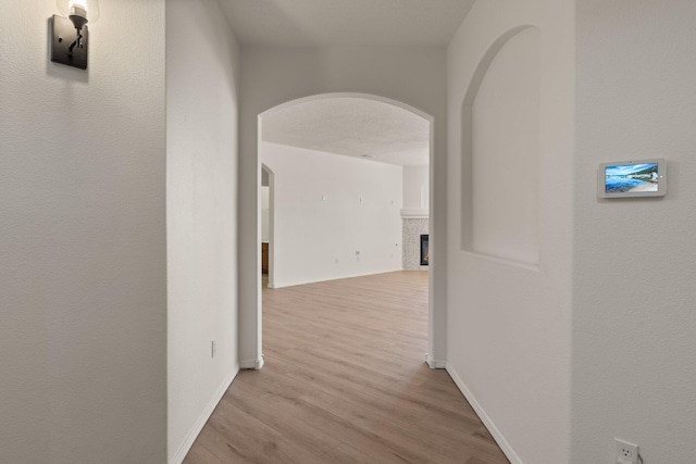 1941 Platina Rd SE, Rio Rancho, NM 87124 - hallway featuring light wood-type flooring, baseboards, and arched walkways