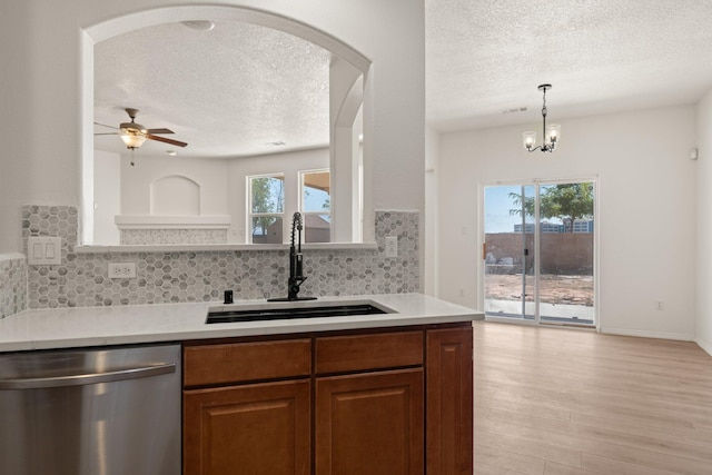 1941 Platina Rd SE, Rio Rancho, NM 87124 - kitchen with stainless steel dishwasher, tasteful backsplash, a textured ceiling, a sink, and ceiling fan with notable chandelier