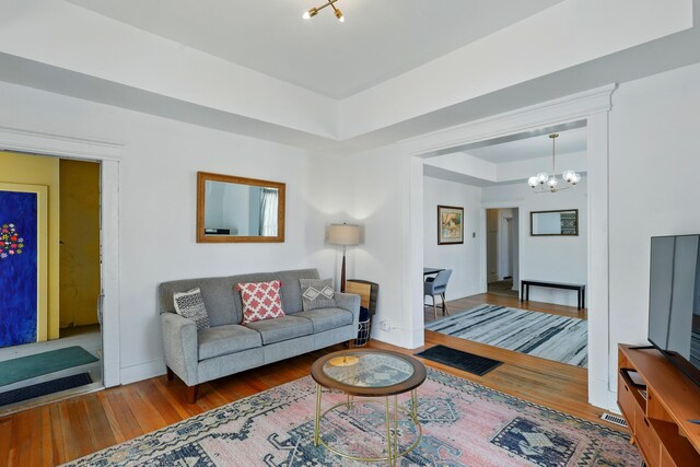 223 Edith Blvd SE, Albuquerque, NM 87102 - living room with a tray ceiling, baseboards, a notable chandelier, and wood finished floors