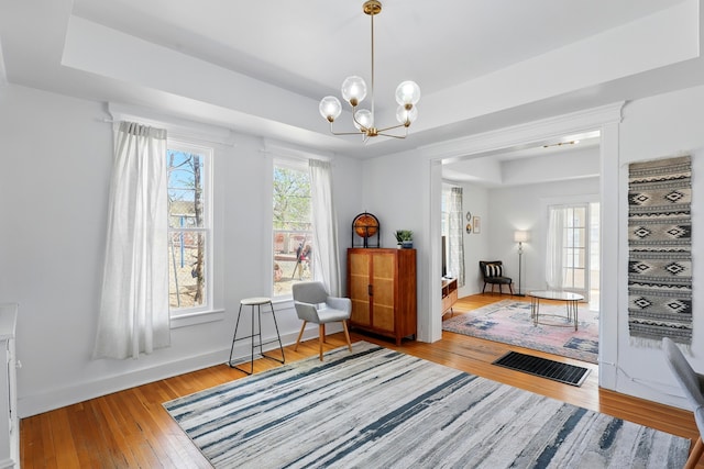 223 Edith Blvd SE, Albuquerque, NM 87102 - living area featuring visible vents, light wood-style flooring, baseboards, a tray ceiling, and a notable chandelier