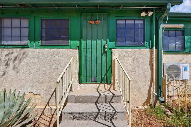 223 Edith Blvd SE, Albuquerque, NM 87102 - doorway to property with ac unit, board and batten siding, and stucco siding