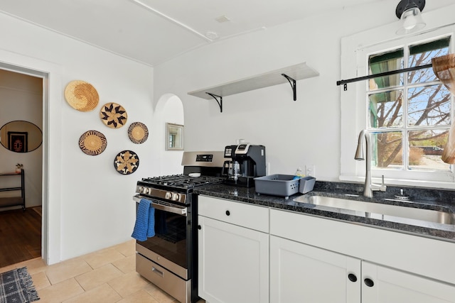 223 Edith Blvd SE, Albuquerque, NM 87102 - kitchen featuring a sink, open shelves, stainless steel range with gas stovetop, dark stone countertops, and light tile patterned floors
