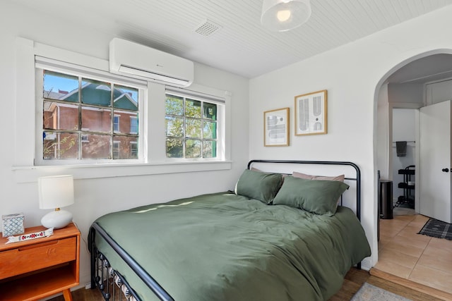223 Edith Blvd SE, Albuquerque, NM 87102 - bedroom featuring arched walkways, an AC wall unit, and tile patterned flooring