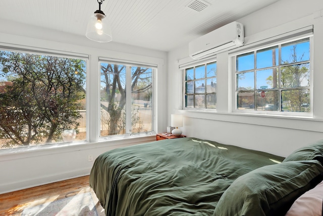 223 Edith Blvd SE, Albuquerque, NM 87102 - bedroom featuring visible vents, wood finished floors, a wall unit AC, and multiple windows