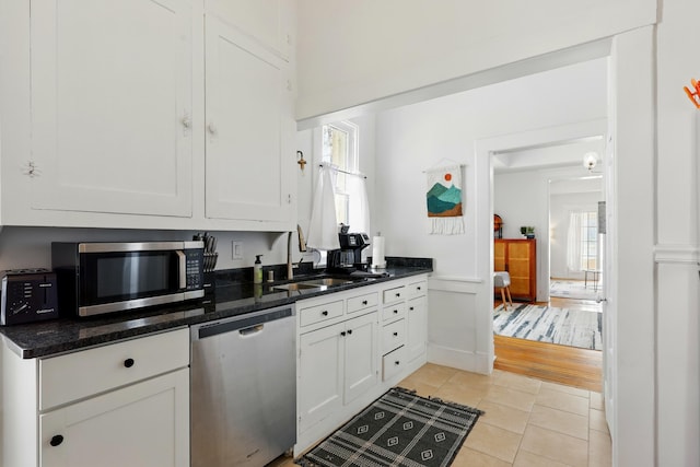 223 Edith Blvd SE, Albuquerque, NM 87102 - kitchen featuring white cabinetry, light tile patterned floors, a sink, and stainless steel appliances
