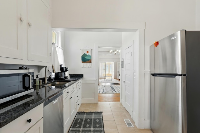 223 Edith Blvd SE, Albuquerque, NM 87102 - kitchen featuring white cabinetry, light tile patterned floors, stainless steel appliances, a sink, and visible vents