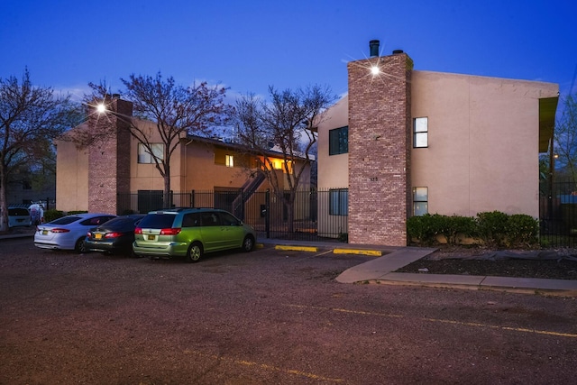 view of property with uncovered parking and fence