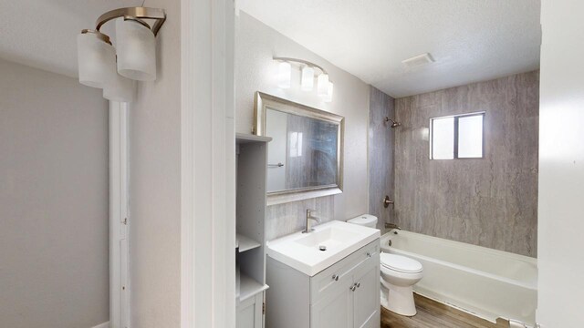 bathroom with wood finished floors, toilet, vanity, and bathtub / shower combination