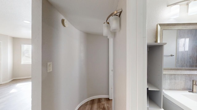 bathroom with baseboards and wood finished floors