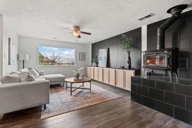 920 Spur Pl SE, Rio Rancho, NM 87124 - living area featuring dark wood-type flooring, visible vents, ceiling fan, and a wood stove