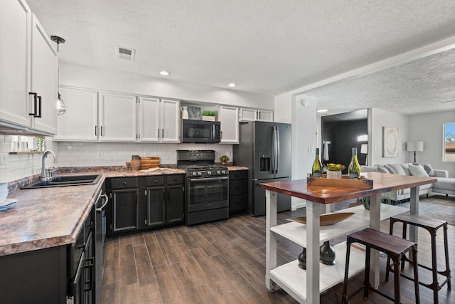920 Spur Pl SE, Rio Rancho, NM 87124 - kitchen with tasteful backsplash, visible vents, dark wood finished floors, stainless steel appliances, and a sink