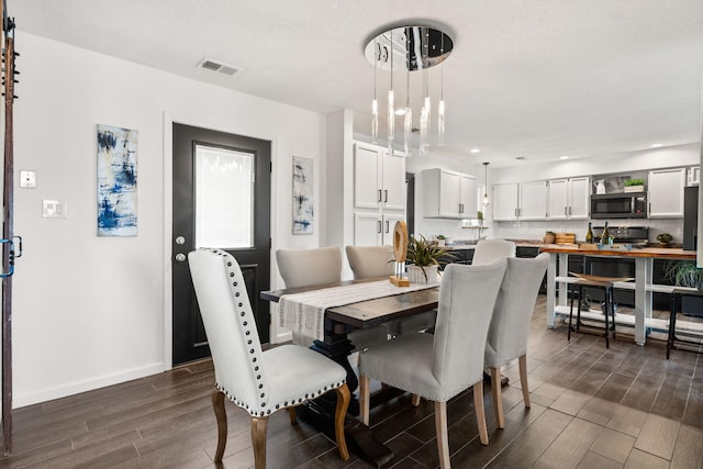 920 Spur Pl SE, Rio Rancho, NM 87124 - dining area featuring dark wood-style flooring, visible vents, and baseboards