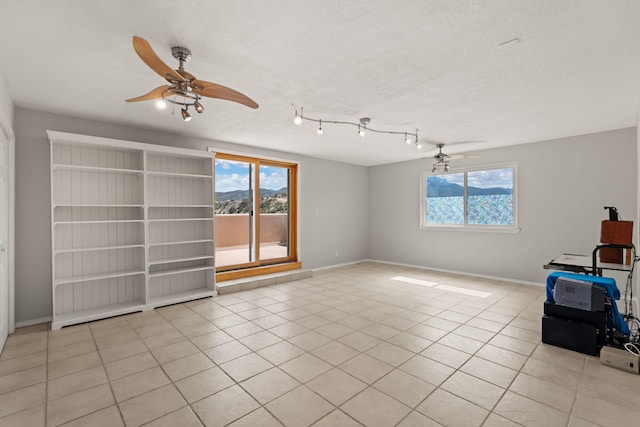 unfurnished room featuring ceiling fan, light tile patterned flooring, and baseboards