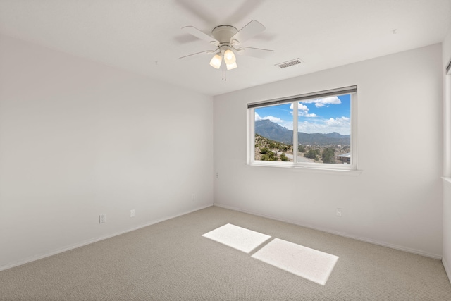 unfurnished room with light carpet, a ceiling fan, and baseboards
