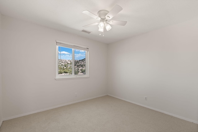 unfurnished room with light colored carpet, baseboards, and a ceiling fan