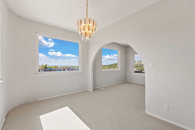 115 Camino De Las Huertas, Placitas, NM 87043 - unfurnished room featuring light carpet, a mountain view, a chandelier, and arched walkways
