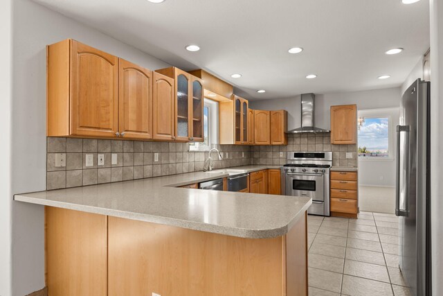 115 Camino De Las Huertas, Placitas, NM 87043 - kitchen featuring wall chimney exhaust hood, appliances with stainless steel finishes, a peninsula, light countertops, and backsplash