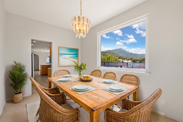 115 Camino De Las Huertas, Placitas, NM 87043 - carpeted dining area featuring a chandelier, a mountain view, and arched walkways