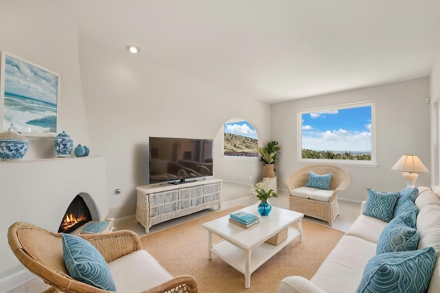 living area featuring a lit fireplace and baseboards